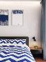 卧室中，设计师在软装布艺上选了灰蓝色，窗帘和床品在色彩上相得益彰，背景画个性有趣味。