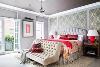 主卧室背景墙上的墙纸选用的是传统的欧式花纹墙纸，红色系的枕头、被单、被罩

以及床头灯底座让卧室感觉上更加温馨。