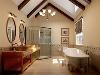卫生间颇有复古韵味，洗手台做了原木风的台上盆，用两面椭圆形镜子做装饰显得空间开阔，古典的浴缸，简洁怀旧、实用舒适。