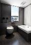 【中建南湖壹号-卫生间】浴室中地面与墙面统一采用黑色，铺贴出黑色时尚，武汉装修白色的浴缸和盥洗台简单大气。