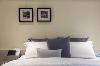 浮见月设计使用鹅黄色造型，让次卧床头墙成为视觉亮点，搭配装饰性相框增添丰富表情，营造温馨舒适的生活氛围。