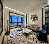 客厅以陶瓷白为主色调，加之宝蓝色沙发的点缀，静谧而优雅。简单的现代家具、展示柜、布艺、护墙板等，使客厅线条感清晰，明净而雅致。