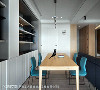 子境设计于餐厅摆设木质长桌搭佐蓝绿色座椅，为用餐空间营造简约温馨感受。