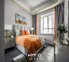卧室
长辈房的设计不再一味追求“素”，而是在沉稳大气的灰调下融入活泼的橙色和闪耀的金色。
在非视觉主体部分运用金边包裹的家具和挂画，增强了空间的生动与时尚。