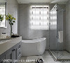 卫浴空间延续整体色调，以干净的灰白色铺垫，并设置独立淋浴间与泡澡浴缸，虽然简单却能感受到家的平实温暖。