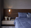 主卧床头墙大面积使用壁布，木纹床头板上装设散发黄光的壁灯，都营造出顶级精品饭店的精致质感。