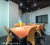 同样以橘色跳色的小会议室，则装设壁挂电视，提供内部员工会议讨论之用。