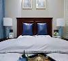 次卧床头用两幅挂画装饰，深蓝色抱枕搭配浅蓝色窗帘，一深一浅，层次感十足；
