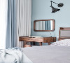 床边设置梳妆区，取代床头柜功能，木色在蓝色背景的衬托下更显质朴质感