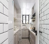 厨房采用白色墙砖工字铺贴，空间呈U字形布局，最大化利用有限的空间