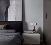 一层主卧室，床头柜选择白色搭配灰色床品与黑色大床，金属色软装提亮空间