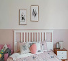 一张白色汉尼斯床架，搭配简约款床头柜，墙面上下分色，错落布置两幅几何图案装饰画，营造清新氛围