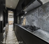 沉邃之美
廊道一侧的独立厨房有着完备的烹饪机能，材料与系统厨具在黑灰演绎下，与公共空间的水泥调性相配衬。
