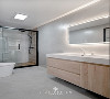 主卫除了淋浴房区域，使用木纹砖上墙，其它部分，大多以灰色为主。
淋浴，以及浴室柜的木色提升卫生间的“温度”。