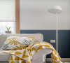 沙发一角黄色的挂毯与抱枕颜色相呼应，背后的上下墙与落地灯来凸显沙发的质感。